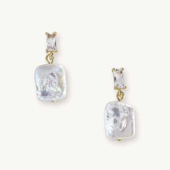 Elegant earrings featuring rectangular gemstones above irregularly shaped, lustrous pearl drops, all set in gold. Sophisticated and stylish.