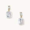 Elegant earrings featuring rectangular gemstones above irregularly shaped, lustrous pearl drops, all set in gold. Sophisticated and stylish.