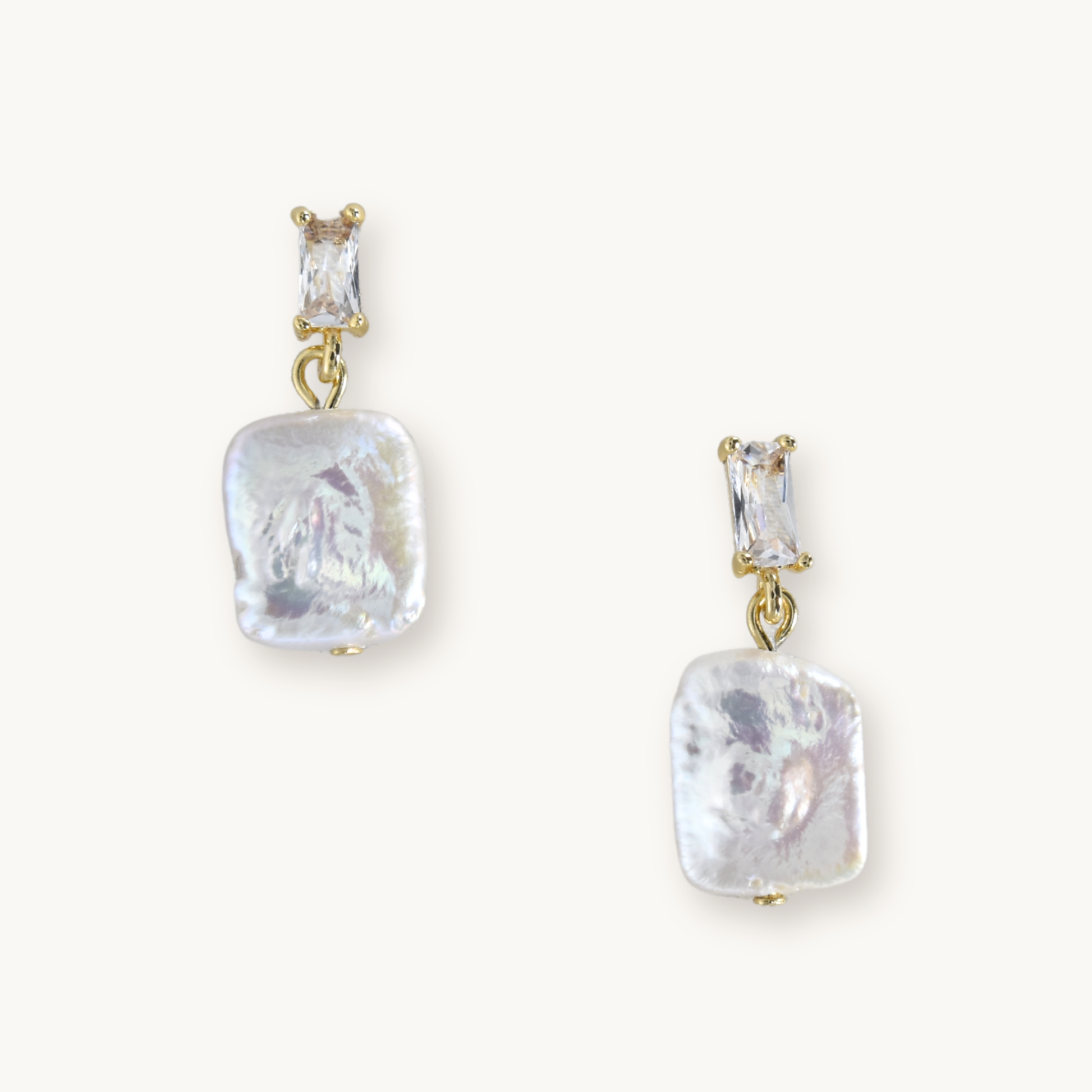 Elegant earrings featuring rectangular gemstones above irregularly shaped, lustrous pearl drops, all set in gold. Sophisticated and stylish.