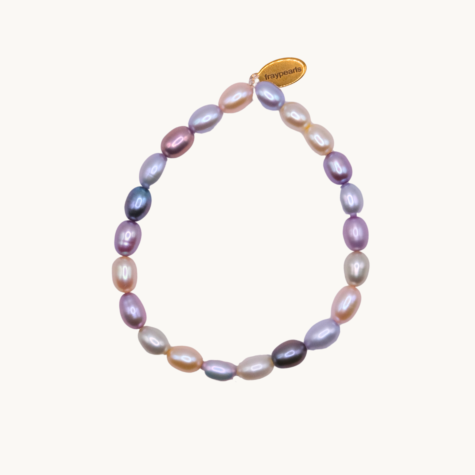 A multicolored pearl bracelet with oval-shaped pearls in hues of purple, pink, blue, and cream. It features a small gold tag with "fraypearls."
