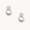 Elegant pearl earrings with sparkling gemstones set in gold. The pearls exude a soft, classic beauty, while the gems add a touch of glamour.