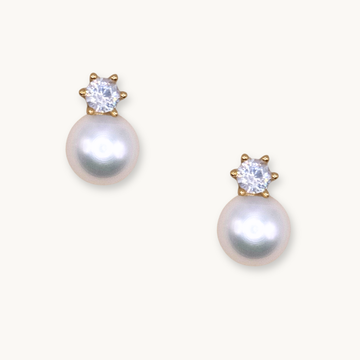Elegant pearl earrings with sparkling gemstones set in gold. The pearls exude a soft, classic beauty, while the gems add a touch of glamour.
