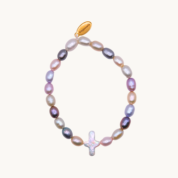 A multicolored pearl bracelet with an iridescent cross charm. The pearls vary in shades of pink, purple, and gold, and there's a small gold tag.