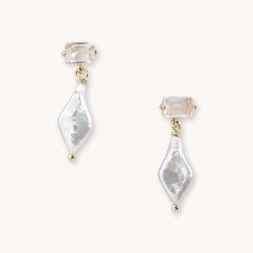 Elegant earrings featuring rectangular gemstones with dangling, irregularly shaped white pearls and gold accents, exuding a refined, sophisticated tone.