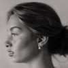 Black and white portrait of a woman with minimal makeup and jewelry.