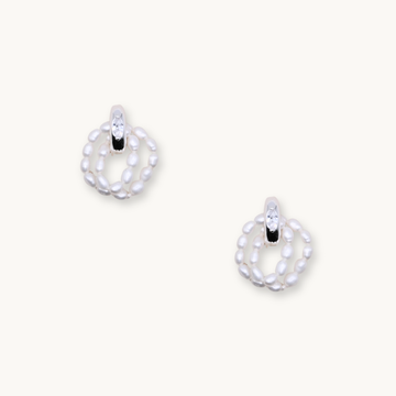 Elegant earrings featuring a loop of small white pearls with a sparkling crystal accent at the top. Set against a light background, they convey sophistication.