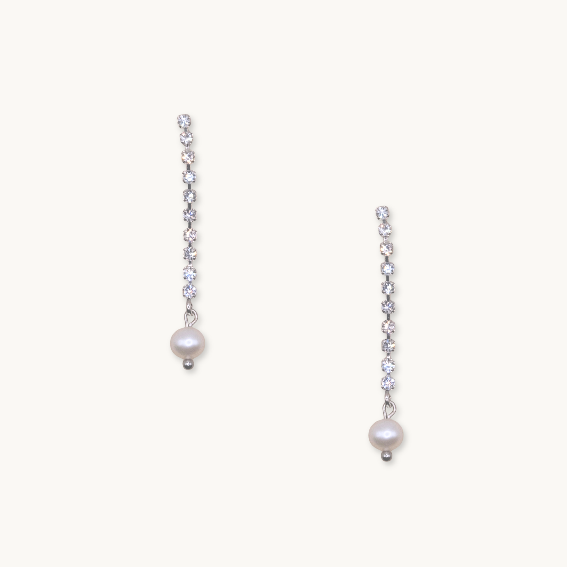Elegant drop earrings with a row of sparkling diamonds ending in a single white pearl. The design conveys a sense of sophistication and timeless beauty.