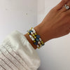 women wearing a mix of blue, green and white pearl bracelets
