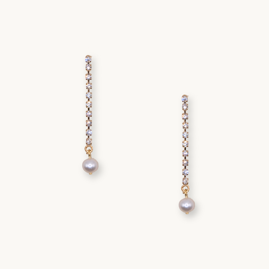 Elegant drop earrings with a row of sparkling diamonds ending in a single white pearl. The design conveys a sense of sophistication and timeless beauty.