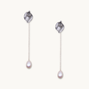 Silver drop earrings with textured petal-like tops and delicate chains ending in teardrop-shaped pearls, conveying elegance and simplicity.