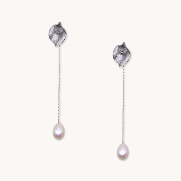 Silver drop earrings with textured petal-like tops and delicate chains ending in teardrop-shaped pearls, conveying elegance and simplicity.