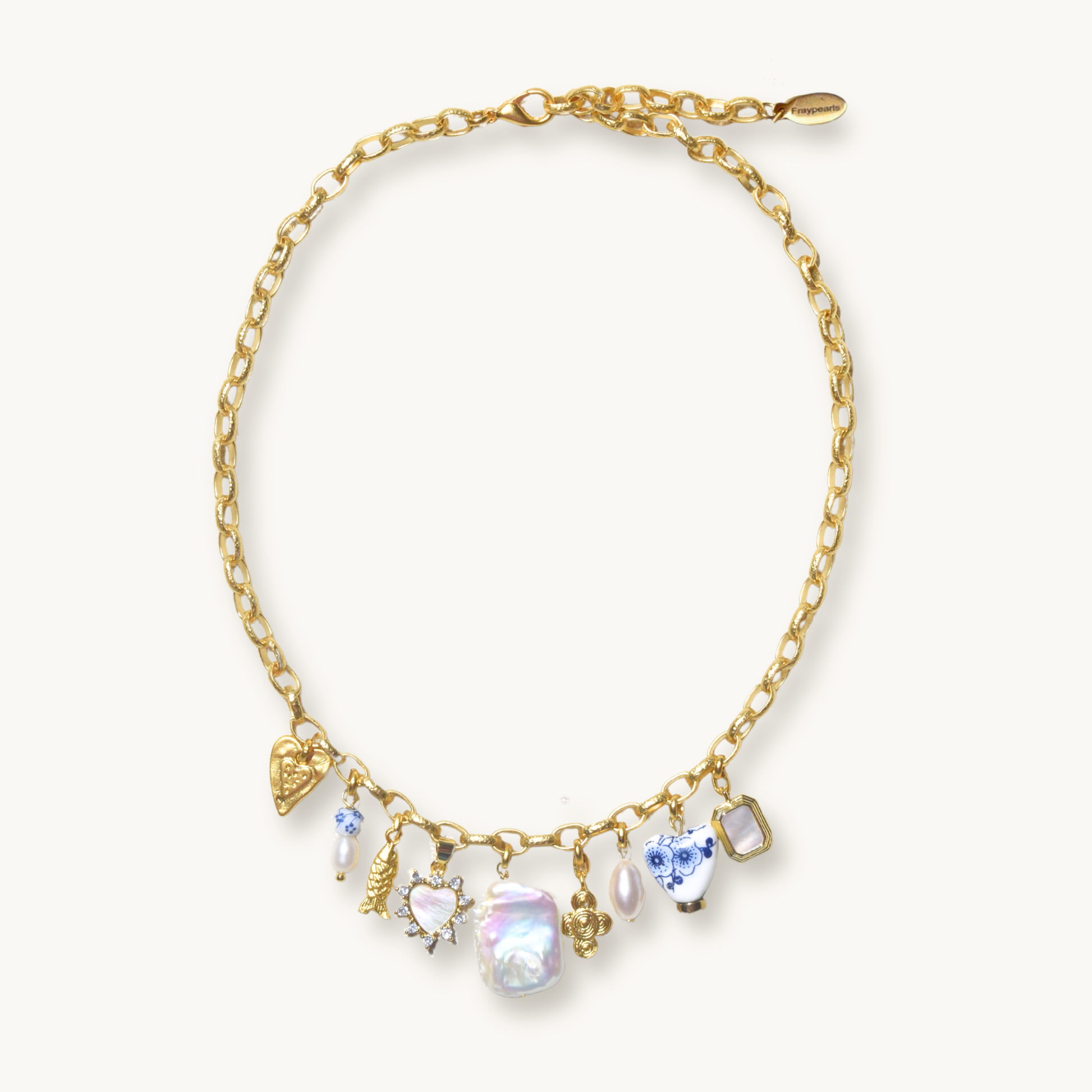 Gold necklace with pearl and alternating shaped charms on a white background