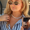Women wearing a blue beaded and white pearl necklace 