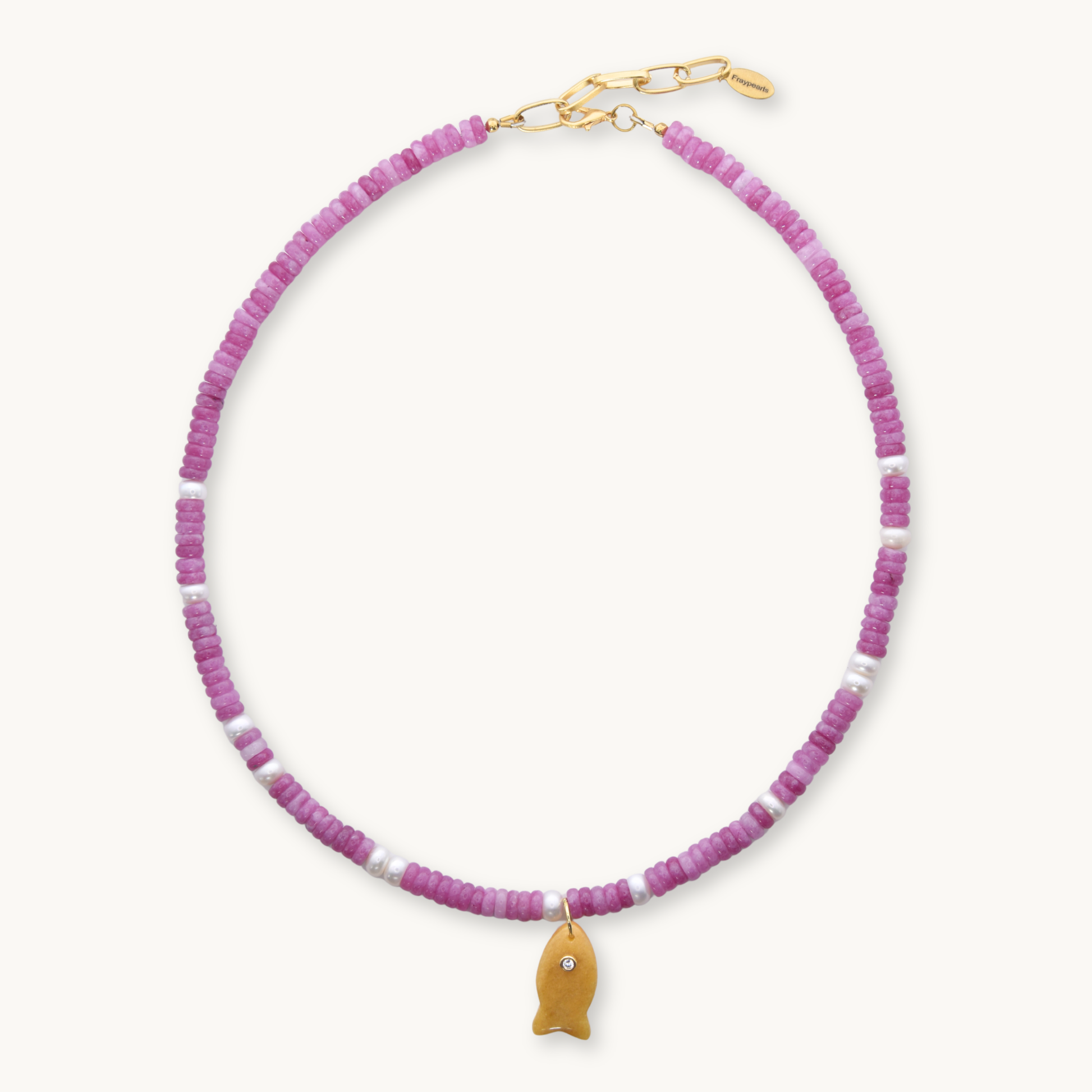 Necklace with pink beads and a gold fish charm on a white background