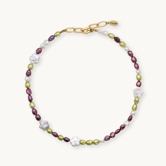 Necklace with green and maroon round pearls with white flower shaped pearls on a white background