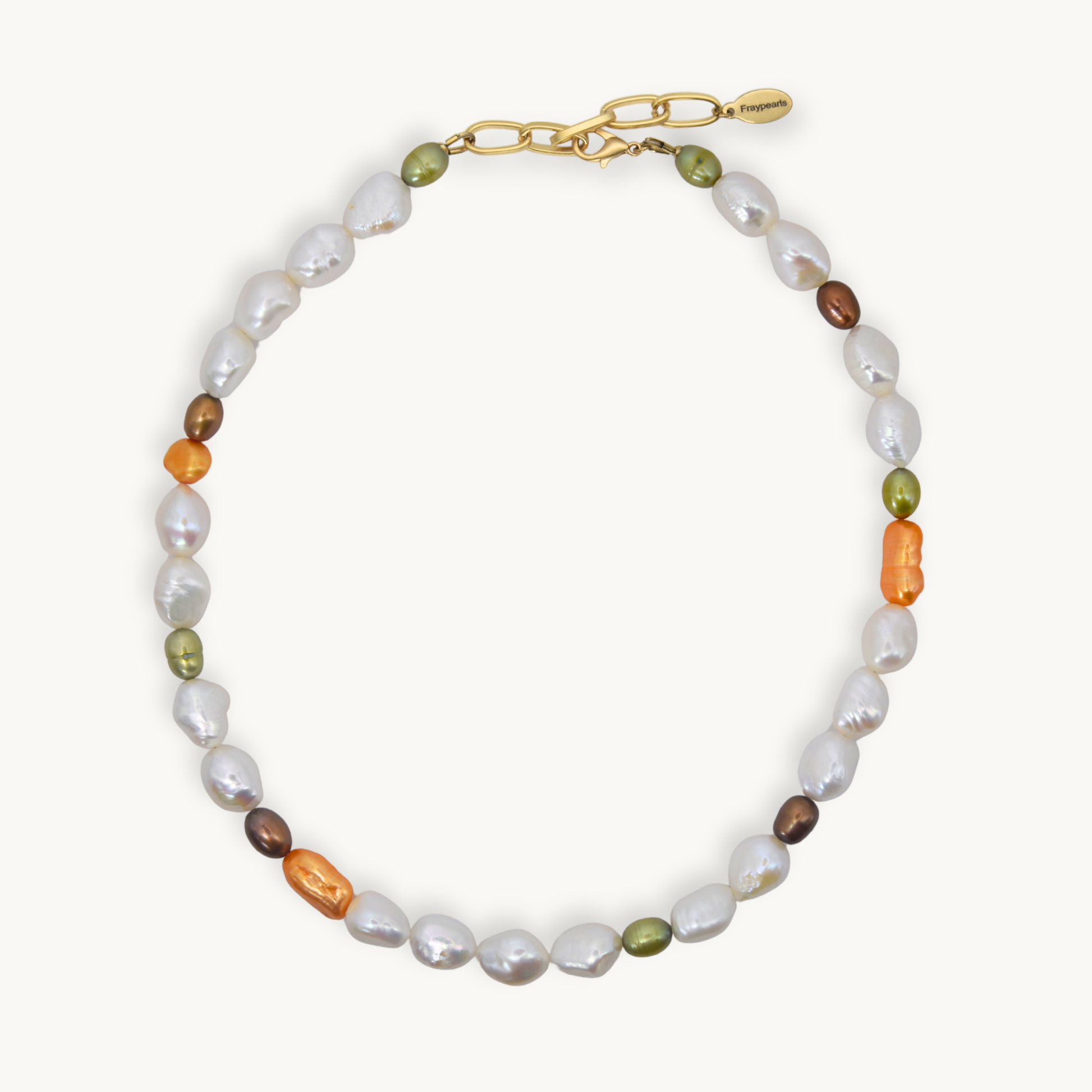 A necklace featuring baroque white, small olive green, brown, and orange pearls, accented with a gold chain clasp, shown on a light cream background.