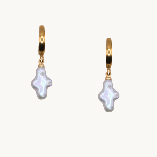 Gold hoop earrings with irregular, light-reflecting white pearls. The pearls have unique shapes, adding an artistic, elegant touch.