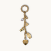 Gold keychain with various charms on a white background