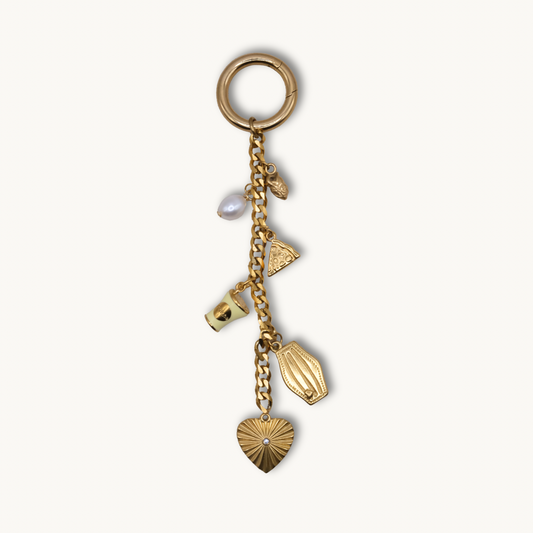 Gold keychain with various charms on a white background