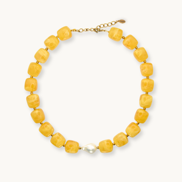 Chunky yellow beaded necklace with pearl and gold closure on white background