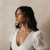 Bride wearing bridal gown with soft curls showcasing her timeless pearl and diamond pairing earrings. 