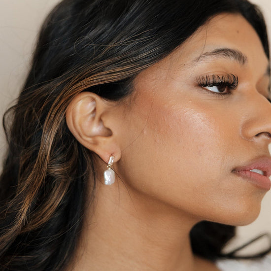 Bride wearing timeless pairing of diamond and pearl earrings.