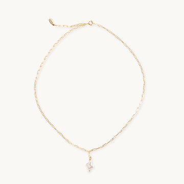 Gold necklace with a small pearl cross pendant on a white background