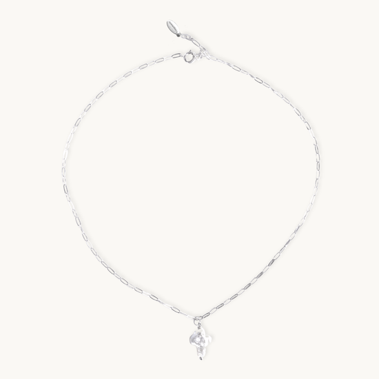 Silver necklace with a small pearl cross pendant on a white background