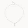 Silver necklace with a small pearl cross pendant on a white background