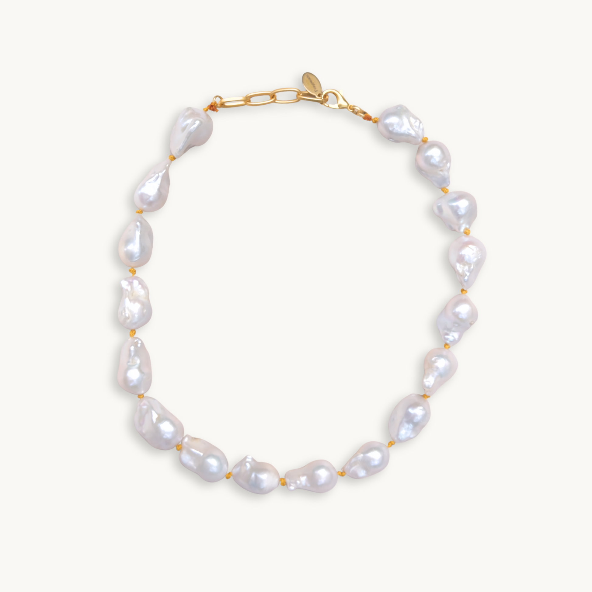 A baroque pearl necklace with irregular white pearls strung along a delicate yellow string. The lustrous pearls convey an elegant, natural look.