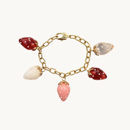 Gold bracelet with strawberry charms in red, pink, white, and clear. Each charm is adorned with tiny pearls, creating a playful, whimsical feel.