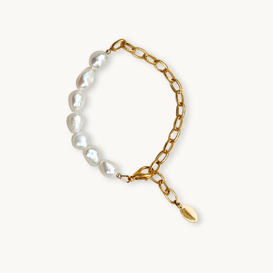 Gold chain bracelet with white pearls on one side, creating a half-and-half design. It features a lobster clasp and a small engraved tag, exuding elegance.