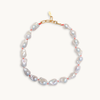 A baroque pearl necklace with irregular white pearls strung along a delicate red string. The lustrous pearls convey an elegant, natural look.