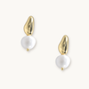Gold and pearl drop earrings on a white background. Each earring features an irregular gold piece above a baroque pearl, giving an elegant, modern look.