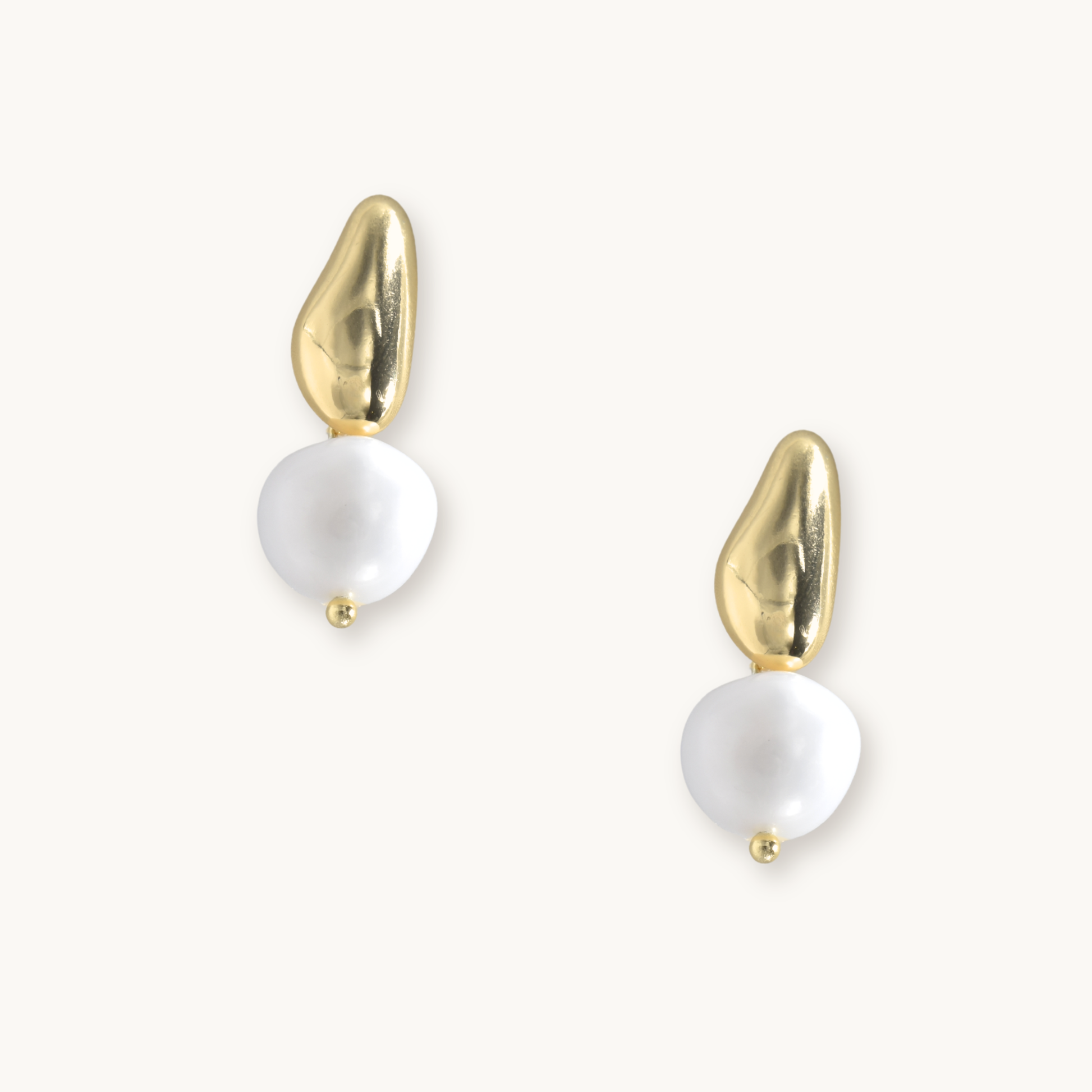 Gold and pearl drop earrings on a white background. Each earring features an irregular gold piece above a baroque pearl, giving an elegant, modern look.
