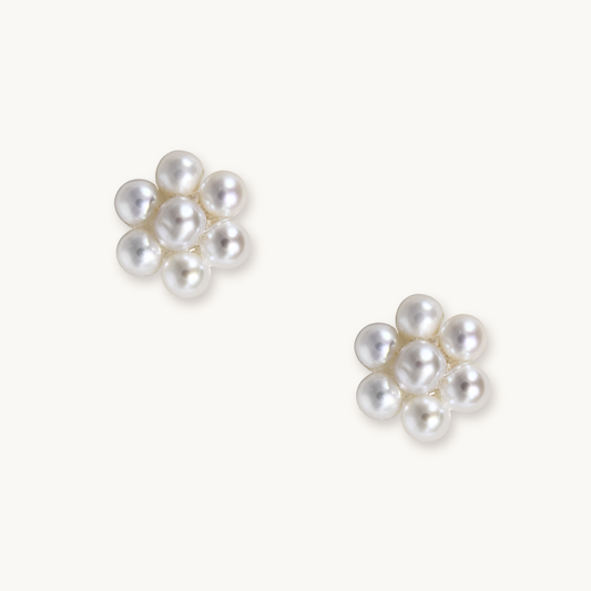 Two small clusters of white pearls arranged in floral shapes on a plain background, creating an elegant and delicate aesthetic.