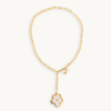 A gold chain necklace with a small flower pendant featuring a pearl inlay, displayed on a clean off-white background.