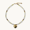 Necklace in chartreuse, white and chocolate brown pearls with a gold heart pendant