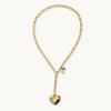 A gold chain necklace with a small heart-shaped pendant, displayed on a clean off-white background.