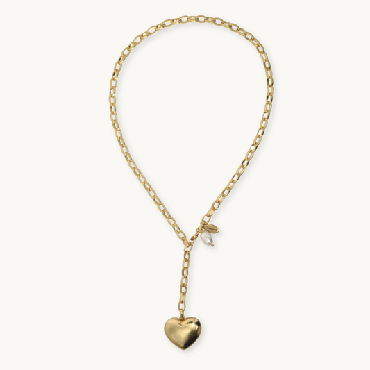 A gold chain necklace with a small heart-shaped pendant, displayed on a clean off-white background.