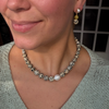 Model wearing a dalmatian jasper and freshwater pearl necklace with a matching beaded drop earring