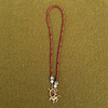 Rust-red sparkly rondelle necklace with dalmatian stones and pearls at each end, joined by a golden toggle clasp with a galloping horse charm.