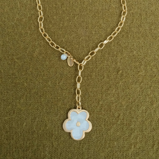 Golden chain lariat necklace ending in a pearl flower pendant, with a pearl drop and Fraypearls tag at the clasp, on olive green knit.
