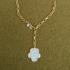 Golden chain lariat necklace ending in a pearl flower pendant, with a pearl drop and Fraypearls tag at the clasp, on olive green knit.