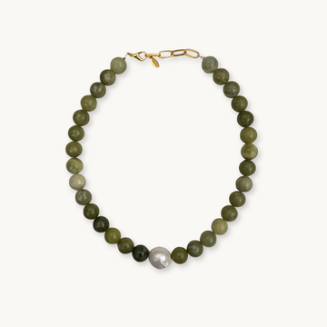 Necklace featuring green round beads with a single large white pearl in the center. Gold clasp on a white background conveys elegance and simplicity.
