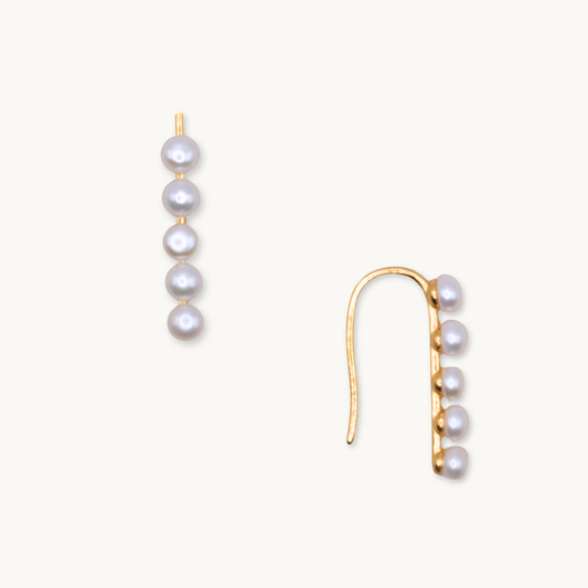 Gold earrings featuring a vertical row of five round white pearls on a hook design, set against a plain white background. Elegant and classy.