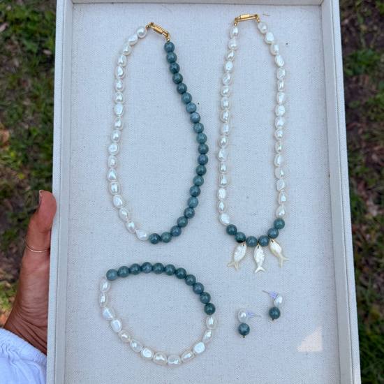 Set of jade and pearl jewelry including two necklaces, an  anklet, and earrings on a jewelry tray.