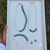 Set of jade and pearl jewelry including two necklaces, an  anklet, and earrings on a jewelry tray.