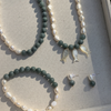 Set of jade and pearl jewelry including two necklaces, an  anklet, and earrings on a jewelry tray.