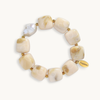 Chunky cream and gold marbled resin bead bracelet with a baroque pearl accent, laid flat on a white background.